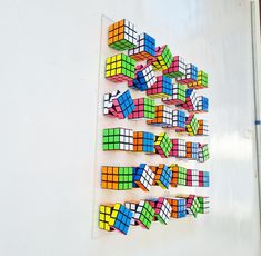 there are many different colored rubiks arranged on the wall in order to make it look like they have been made out of paper