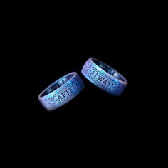 two wedding bands with the words atlanta engraved on them, against a black background that is lit up