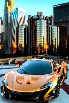 an orange sports car parked in front of a cityscape with skyscrapers behind it