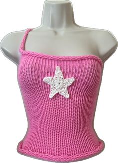 a pink knitted top with a white star on the front and bottom, as well as