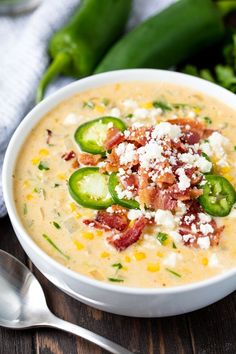 a white bowl filled with soup and topped with bacon, cheese and jalapenos