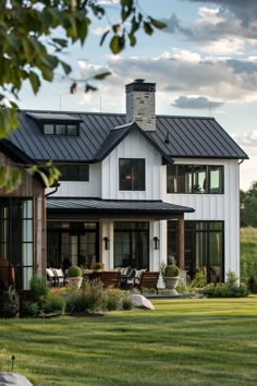 a large white house sitting on top of a lush green field