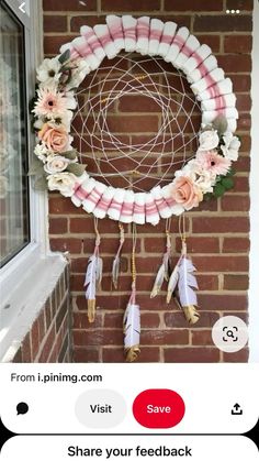 a wreath made out of marshmallows and feathers with flowers hanging from it