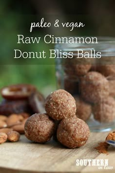 raw cinnamon donut bliss balls on a cutting board with other nuts in the background