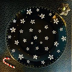 a black plate with white flowers and candy canes