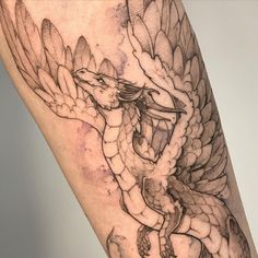 a close up of a person's leg with a tattoo design on it and a dragon