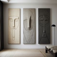 three abstract paintings hang on the wall above a bed