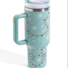 thermos cup with handle is decorated with christmas lights and snowflakes on it