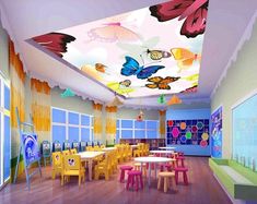 a classroom with many tables and chairs in the center, painted butterflies on the ceiling