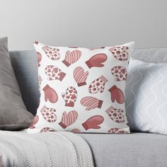 a white couch with pink and red hearts on it throw pillow sitting on top of it