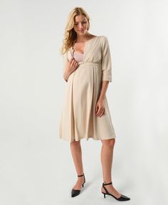 Where power meets femininity, the Sarah is the go-to confidence booster in your maternity wardrobe. The stunning pleated skirt ends in an empire waistline perfect for all different kinds of tummy days. Bonus, the skirt hides two HUGE pockets - a mama's best friend. The Sarah's dramatic cuffs, lightly padded shoulders, and adjustable v-neckline with teardrop zip (perfect for nursing) make this an unforgettable statement piece. Its easy, flattering silhouette will make it one of the most effortles Breastfeeding Dress, Dress Feminine, Maternity Wardrobe, Feminine Skirt, Workwear Essentials, Maternity Nursing Dress, Pregnancy Wardrobe, Empire Waistline, Nursing Tops