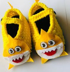 a pair of yellow slippers that have been made to look like a baby shark