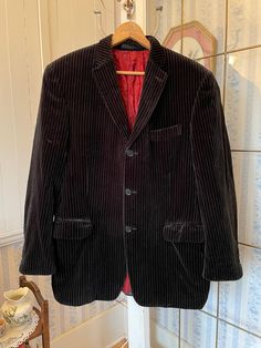 This classic Kenneth Cole jacket was sold in Winnipeg by Romolo Fracassi Clothier and Tailors. It's made of very soft cotton velvet in black with fine white pinstripes. It has the original buttons down the front and on the cuffs (even on one inside pocket!); three outer pockets and four inner pockets (one specifically for a pen); and is fully lined with burgundy red silky lining. The measurements, taken with the coat lying flat, are: shoulder to shoulder, 18 inches; armpit to armpit, 21 inches; sleeves, 25 1/2 inches; length, 32 inches; bottom edge, 20 inches. Some wear is visible on the lining, but overall the coat is in very good condition. Black Velvet Jacket, Jacket Sport, Velvet Blazer, Sports Blazer, Velvet Jacket, Coat Black, Cotton Velvet, Black Blazer, Burgundy Red