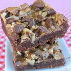 two chocolate brownies stacked on top of each other, with nuts and pecans in the middle