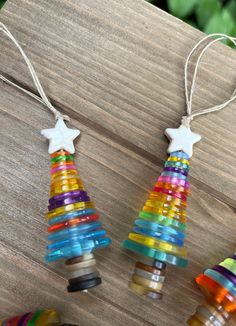 three christmas trees made out of glass beads on a wooden table with string and star ornament hanging from the top