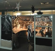 an office decorated for christmas with lights and decorations on the windows, along with chalkboard writing