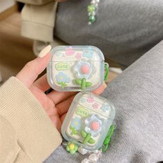 two plastic containers with flowers on them are held in someone's hand while sitting down