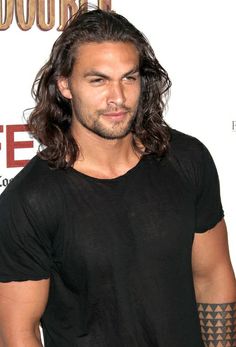 a man with long hair wearing a black shirt