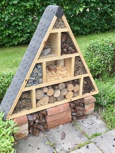 a building made out of wood and rocks in the shape of a pyramid with various items inside