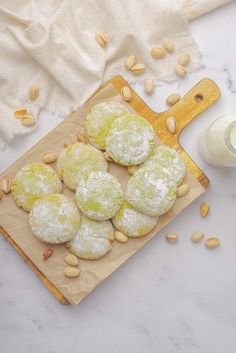 almond and pistachio cookies on a cutting board next to a bottle of milk