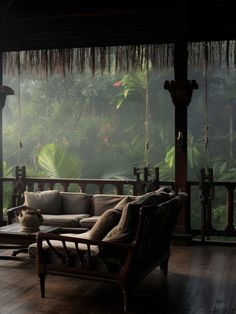 a living room filled with furniture and lots of greenery