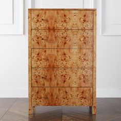 a wooden dresser sitting on top of a hard wood floor next to a white wall