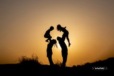 two people are silhouetted against the setting sun