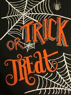 a trick or treat sign with spider webs and orange lettering on black paper that says trick or treat