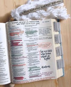 an open bible sitting on top of a wooden table