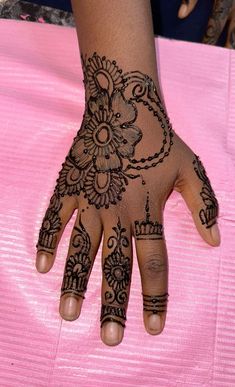 a woman's hand with henna tattoos on it