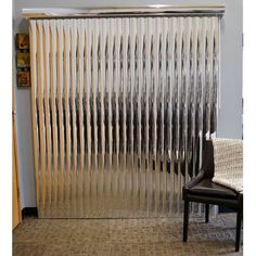 a chair sitting in front of a window with metal slats on the outside and inside