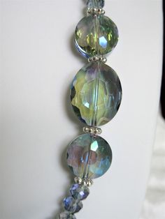 "Pale blue gray crystals were used to make this necklace. The largest is 1\" x 3/4\" x 1/4\" thick. The smallest are 4x6mm. The spacers are silver plated rondelles. A 3\" extender is included. The earrings, made with slightly more than 1/2 inch flat rounds, dangle 1\" from the loops of the silver plated ear wires. All metals are silver plated. This set will be slipped into an organza bag and shipped in a bubble mailer." Iridescent Crystal Jewelry With Faceted Beads, Gray Crystals, Irish Cross, Gold Sand, Crystal Jewelry Sets, Bubble Mailer, Faceted Glass, Black Crystals, Organza Bags