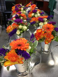 several silver vases filled with different colored flowers