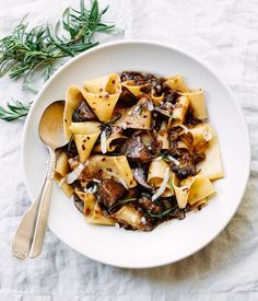 a white plate topped with pasta and mushrooms