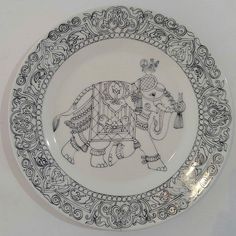 a plate with an elephant on it is shown in black and white, as well as ornate designs