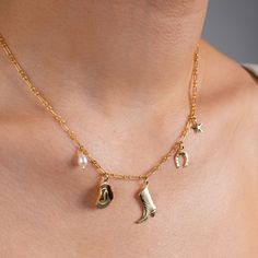 Drape yourself in the essence of the wild and refined with our Stampede Charm Necklace -- an ode to adventurous spirits and serene desert nights, featuring a delicate freshwater pearl and whimsical western charms, including a cowboy hat, boot, lucky horseshoe, and a twinkling star.  What is Gold Filled? Gold Filled is 5% gold by weight, which is 100x more gold than gold-plating. Gold filled is waterproof, hypoallergenic, tarnish-resistant, will last for years to come, and doesn't carry the hefty Western Baddie, Bachelorette Cowgirl, Bachelorette Nashville, Western Necklaces, Nashville Bachelorette, Chapeau Cowboy, Lucky Horseshoe, Party Summer, Gold Charm Necklace