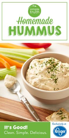 a bowl of hummus next to celery and carrots