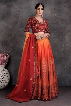 Be a vision of style and elegance on wedding celebrations in this stunning maroon and orange printed and embroidered lehenga with dupatta. Shop Indian dresses in USA from Pure Elegance.