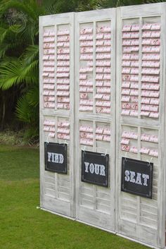 an outdoor display with pink and black signs on it's sides, in front of palm trees