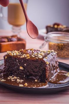 a piece of chocolate cake on a plate with a spoon sticking out of the top