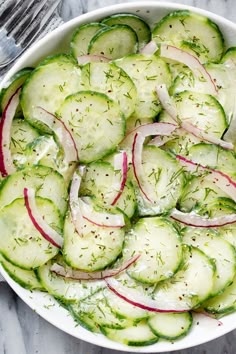 a white bowl filled with cucumbers and onions