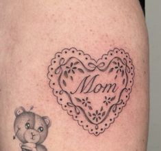 a tattoo with a teddy bear holding a heart and the word mom written on it