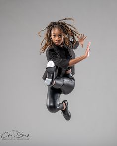 a woman dressed in black jumping into the air