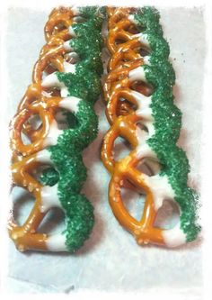 two pretzels with green and white frosting on them sitting next to each other