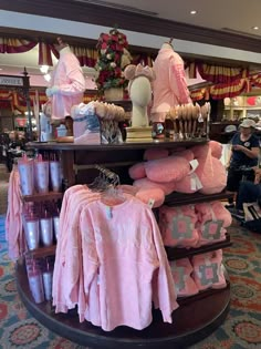 a display in a store filled with lots of pink sweaters and other clothing items