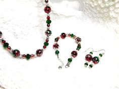 This makes a great gift for the holidays.  The beads used for the set are 6 and 12mm red beds with streaks of green and silver in them, 5, 7, 9 mm green facet cut glass beads and 6mm silver ball beads.  The chains are silver and adjustable for the necklace and bracelet and they both have a silver heart on the end of the extender chain.  The necklace is 18.5 to 21.5 inches long and the bracelet is 7.5 to 8.5 inches long and the earrings have a drop of 1.5.  This makes a great colorful set for Christmas or any time of year. If you need the length changed, send me a message so I can check on bead availability. Red Beds, Bracelet Christmas, Red Bedding, Green And Silver, Christmas Jewelry, Jewelry Necklace, Necklace Earrings, Cut Glass, Silver Heart