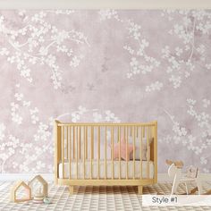 a baby crib in front of a wall with flowers on it