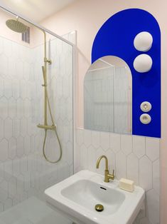 a white sink sitting under a bathroom mirror next to a blue and white tiled wall