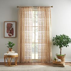 a living room with a large window covered in sheer curtains