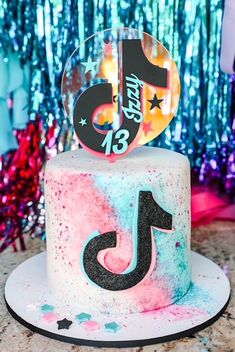 a birthday cake with the number thirteen on it and stars around it, sitting on a table